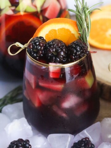 Blackberry Sangria filled in stemless wine glass.