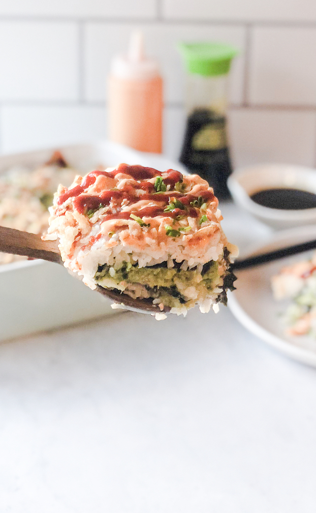 a close up view of a scoop of crab sushi bake 