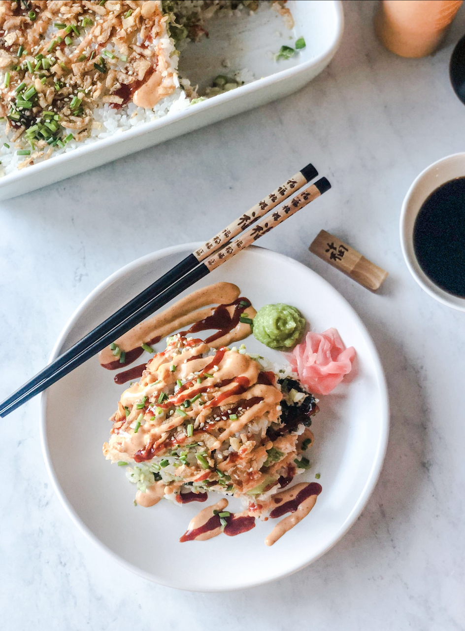 plated crab sushi bake with chopsticks on the side, and soy sauce and the casserole dish in the background