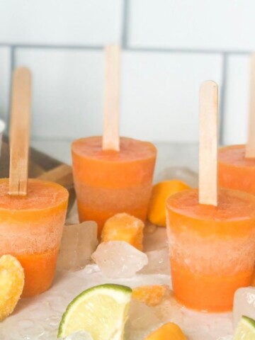 Sangria Margarita Boozy Pops with frozen mangos and lime slices.