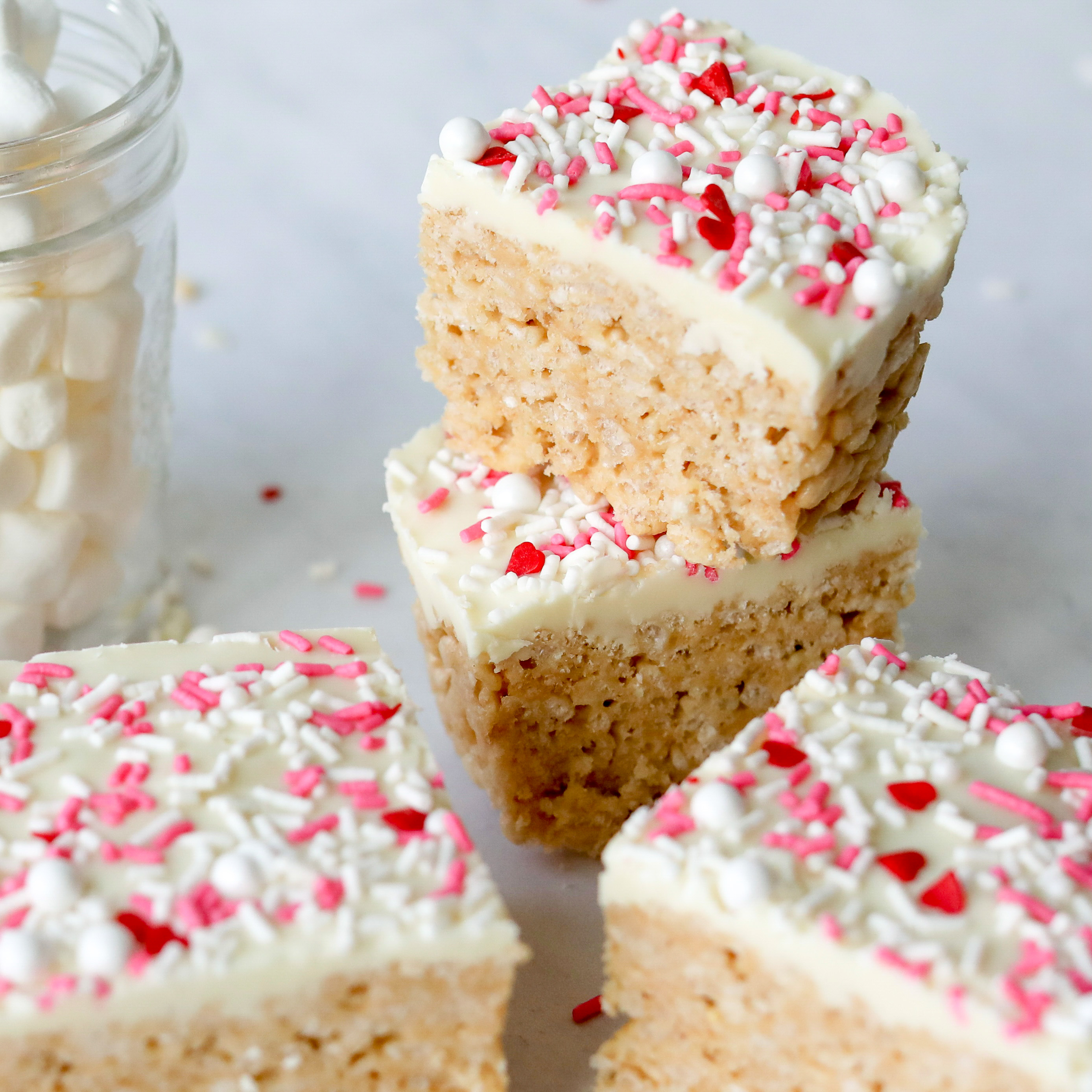 Easy Kid Friendly Valentine's Inspired Cereal Bar with one bar in focus showing themed sprinkles on top.