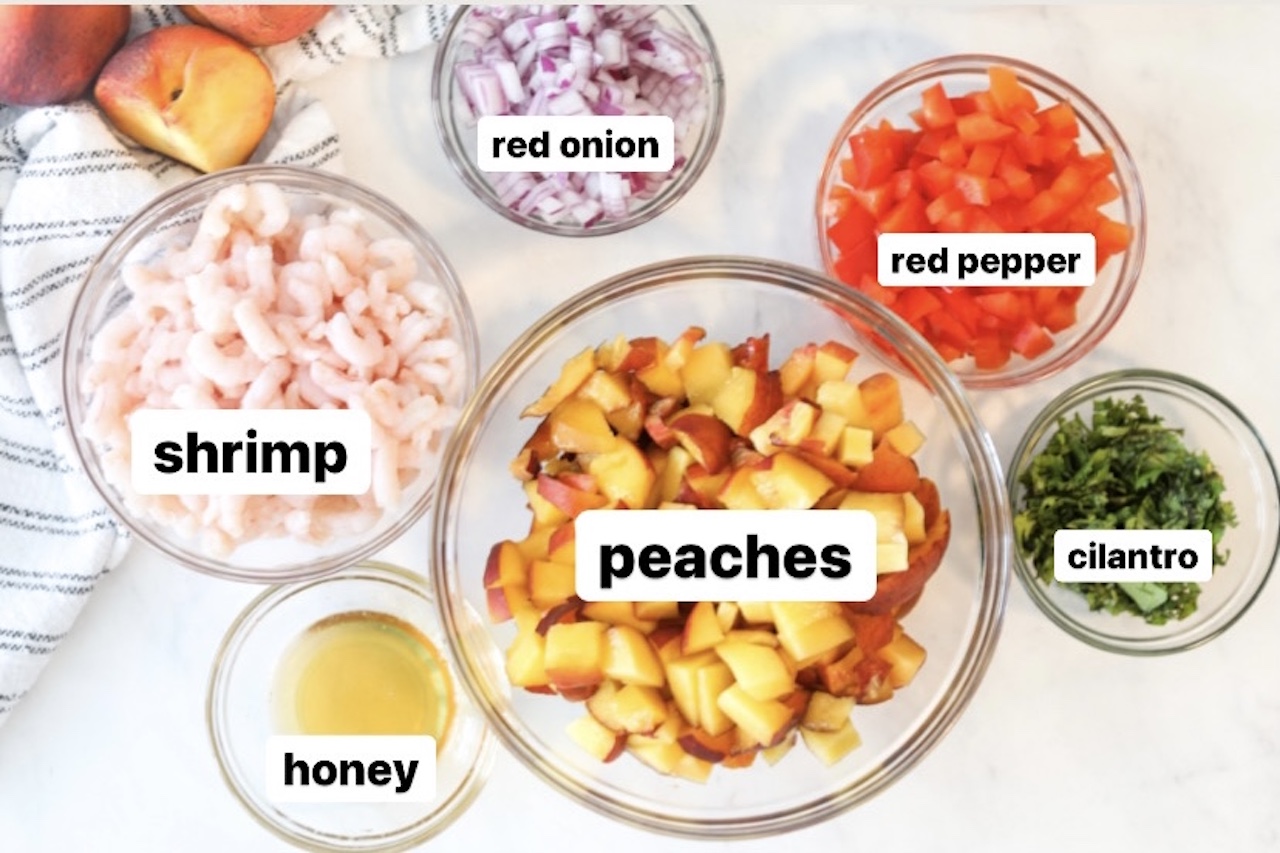 Peach Salsa with Shrimp Recipe Ingredients. Six bowls varying in sizes housing recipe ingredients; peaches, shrimp, honey, red onion, red pepper and cilantro. For styling purposes; black and white striped towel with three peaches in the left corner of the screen.There are labels over each bowl describing each ingredient; words in black and outlined in white.