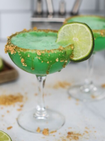 Key Lime Martini, rimmed with crumbled graham crackers and garnished with a lime.