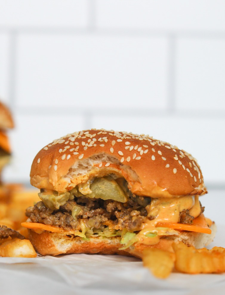 Bite shot of Big Mac Sloppy Joe burger with fries added for styling purposes.