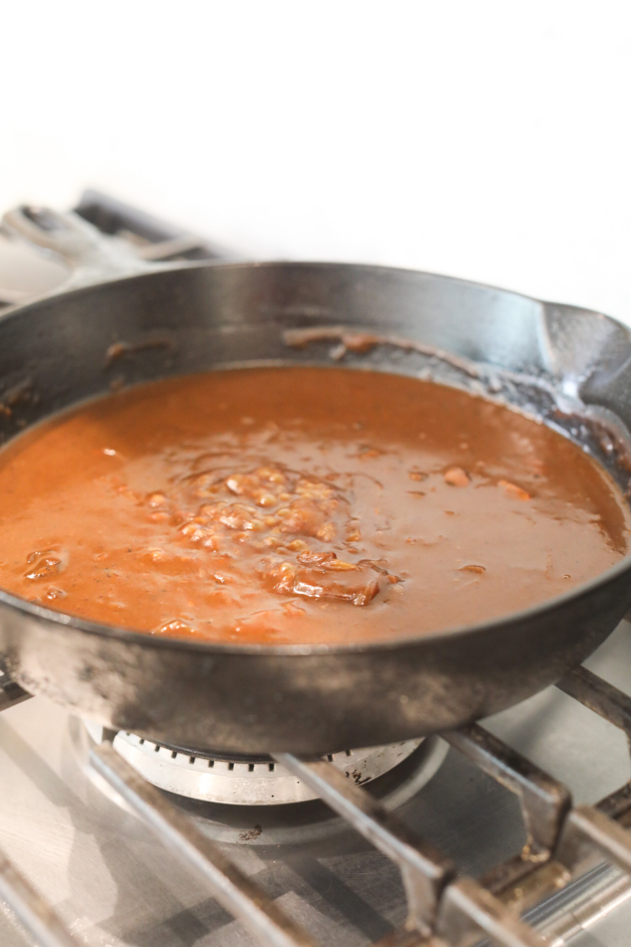 Loco Moco Brown Gravy Recipe in a black cast iron skillet on a gas stove.