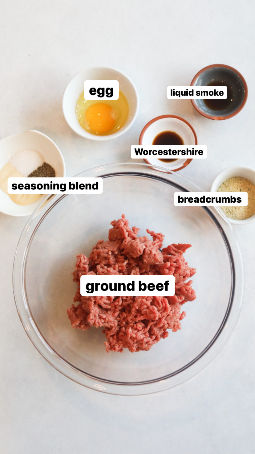 Loco Moco recipe ingredients in various sized clear and white bowls. Ground beef is in the center in a clear bowl, small white bowls filled with seasoning blend, egg, Worcestershire, liquid smoke and breadcrumbs.