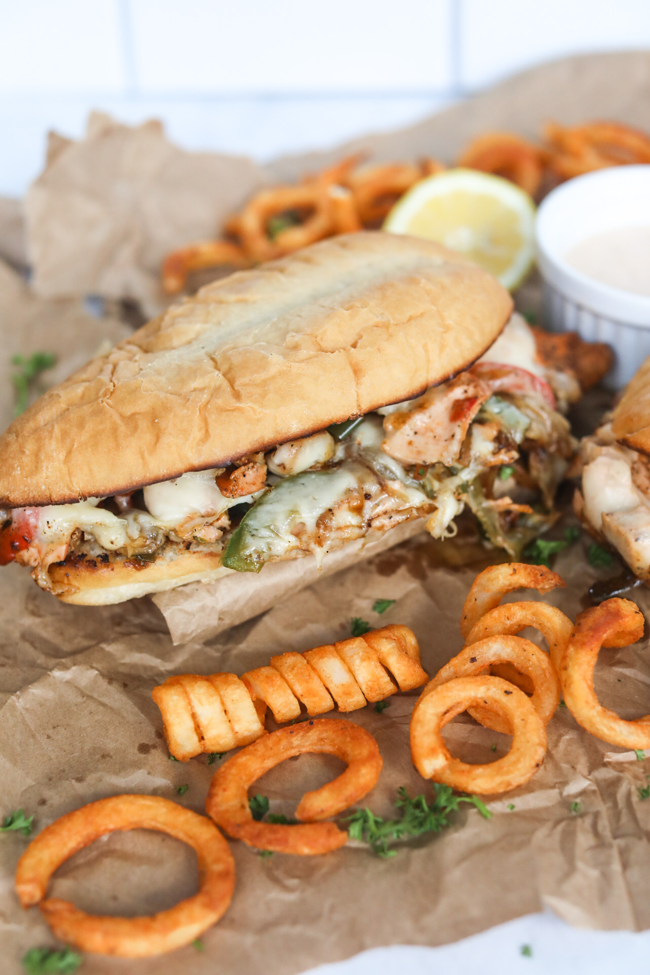 Salmon Cheese Caked styled with curly french fries and a white sauce bowl filled with remoulade sauce.