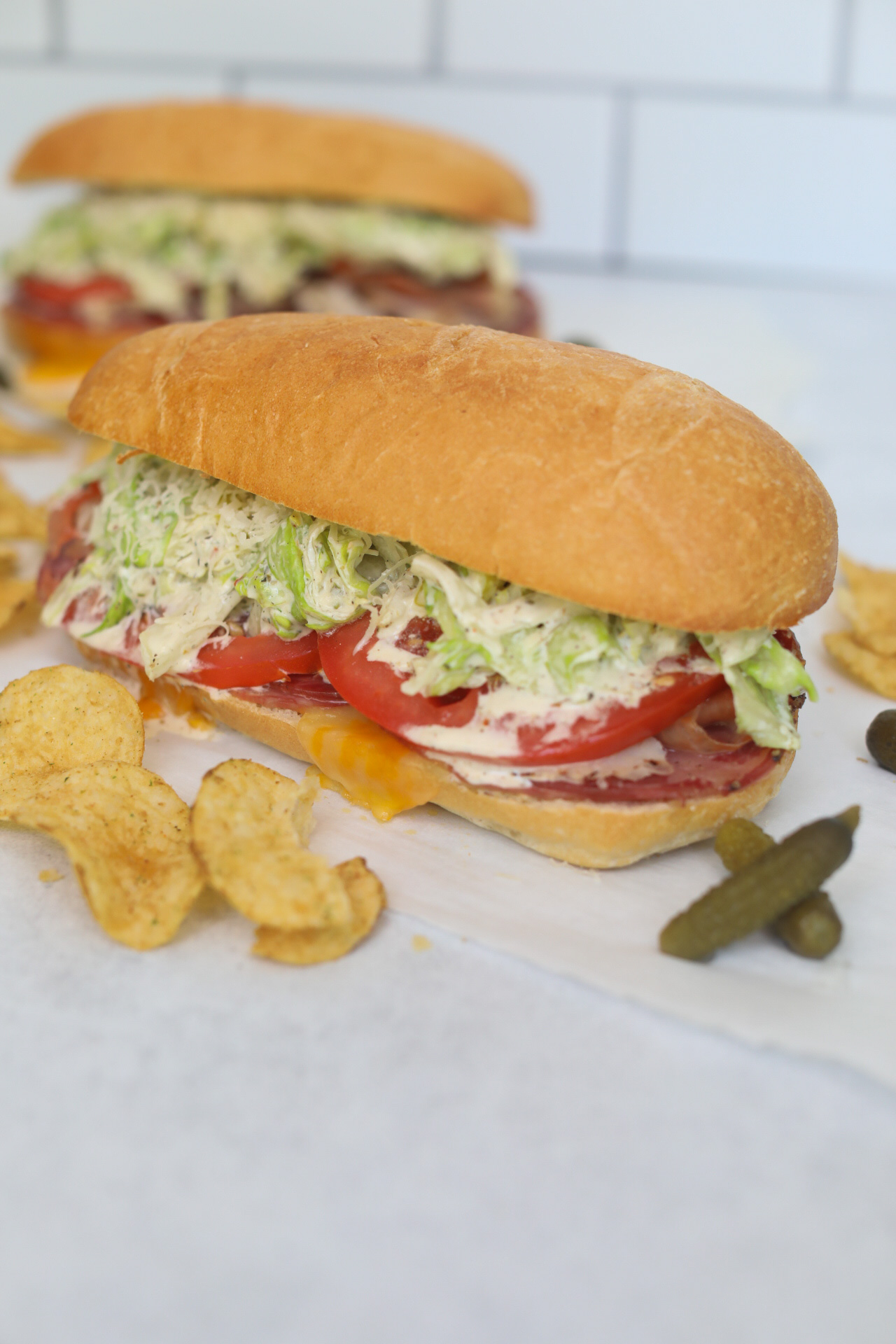 Italian Grinder Salad Hoagie from an angled view. Chips and pickles are added for styling purposes.