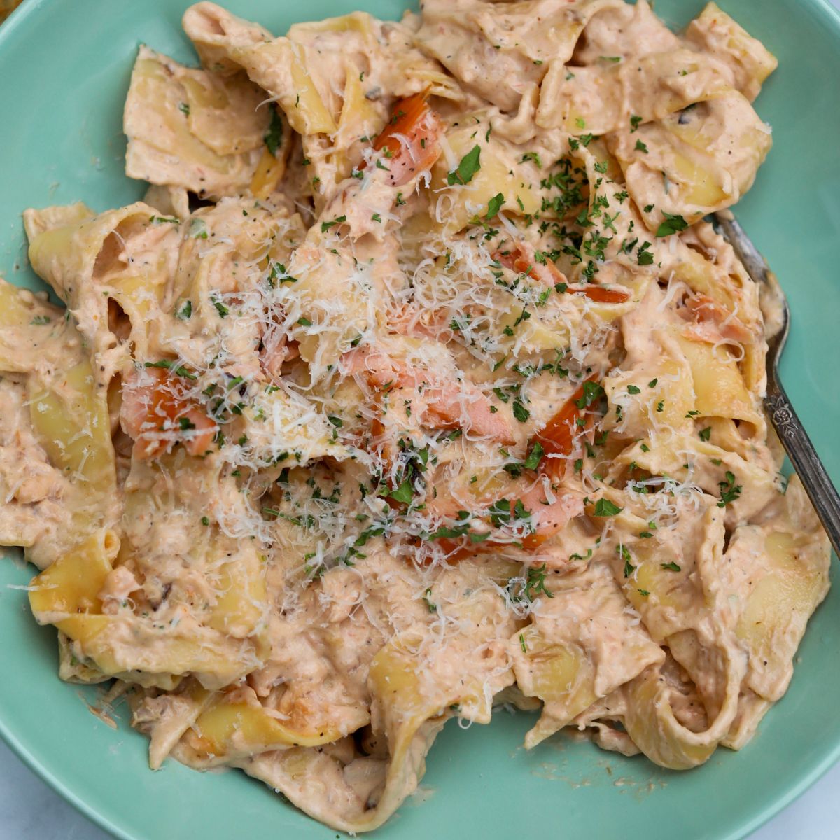 Top Down view of pasta al salmone recipe plated in a light teal shallow bowl.
