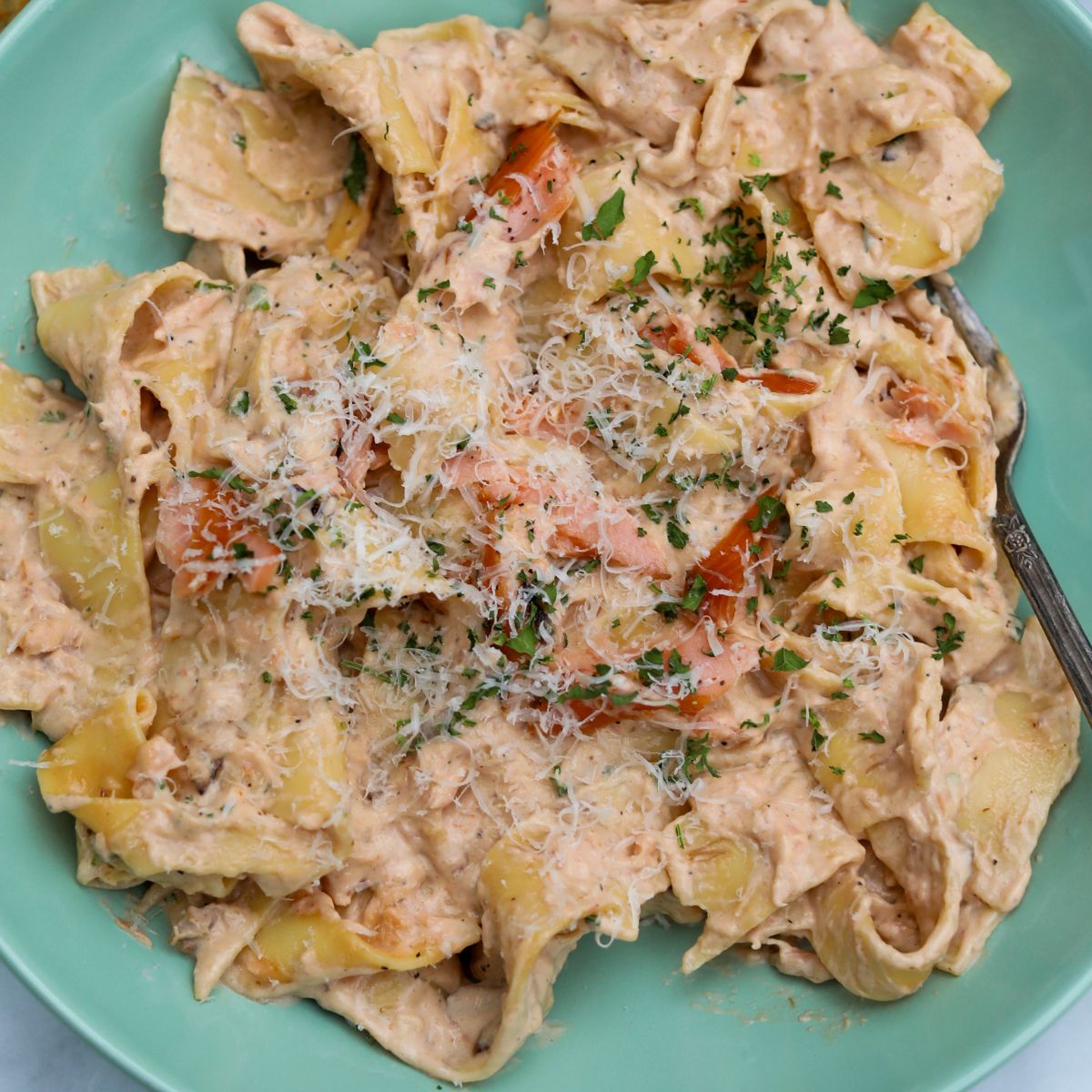 Top Down view of pasta al salmone recipe plated in a light teal shallow bowl.