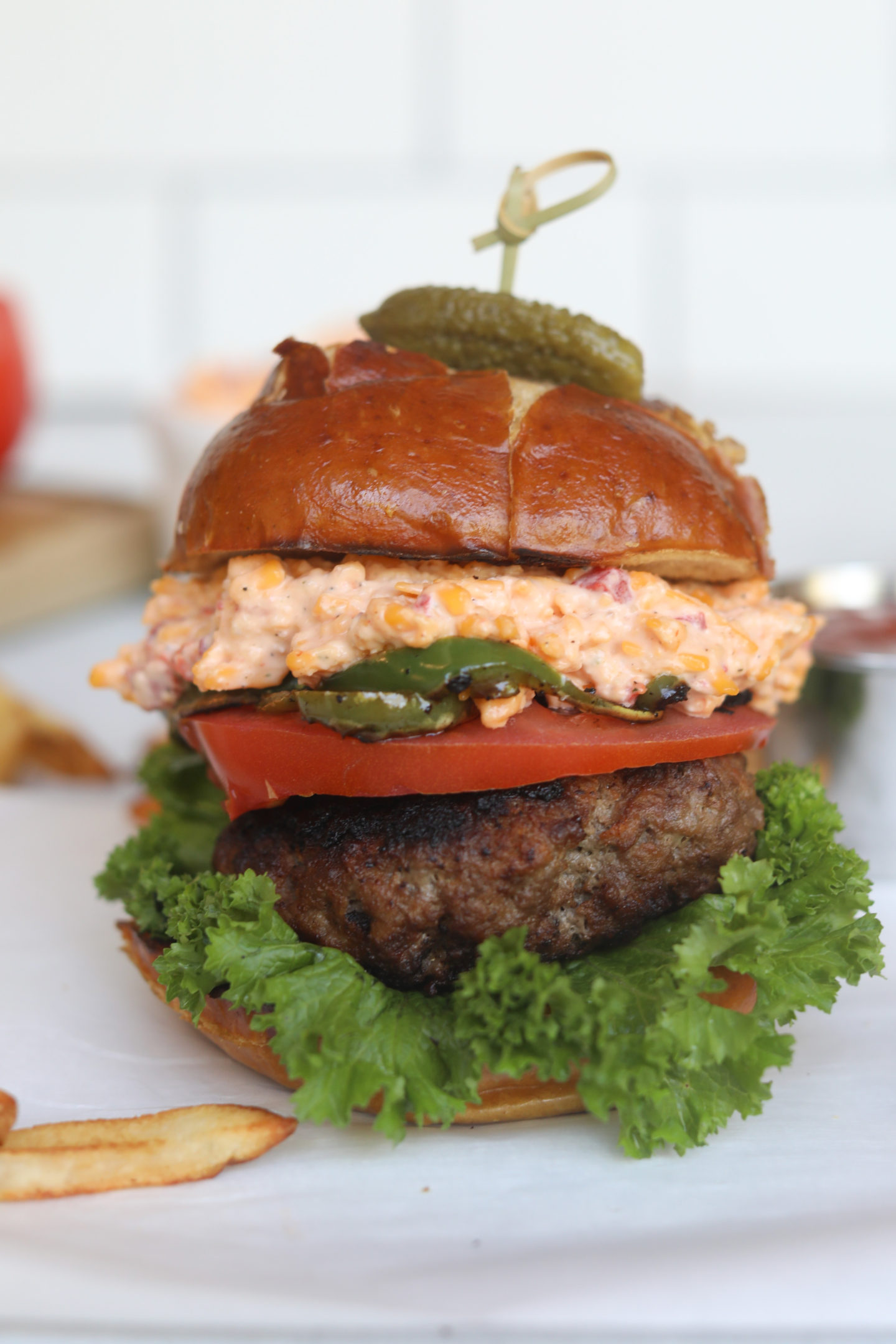 Pimento cheese burger final shot image with fries added around the burger for styling purposes.