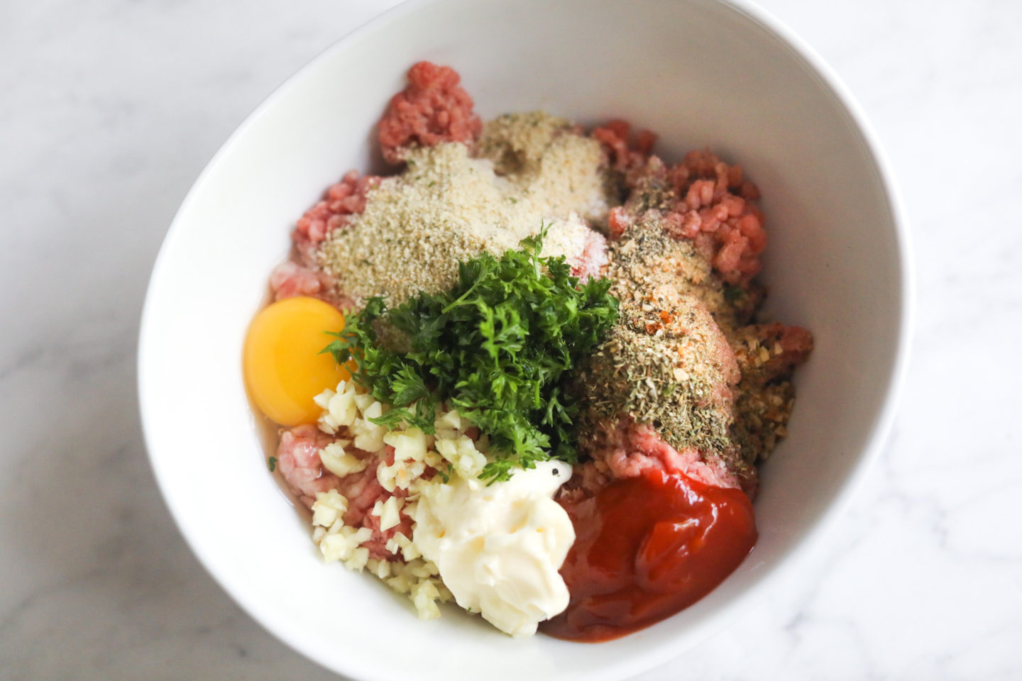 ingredients for meatballs in a bowl before being combined