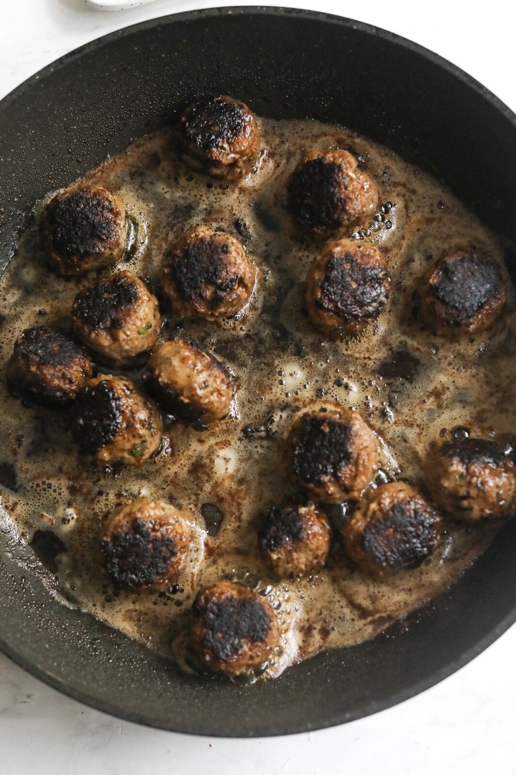 browned meatballs in a skillet