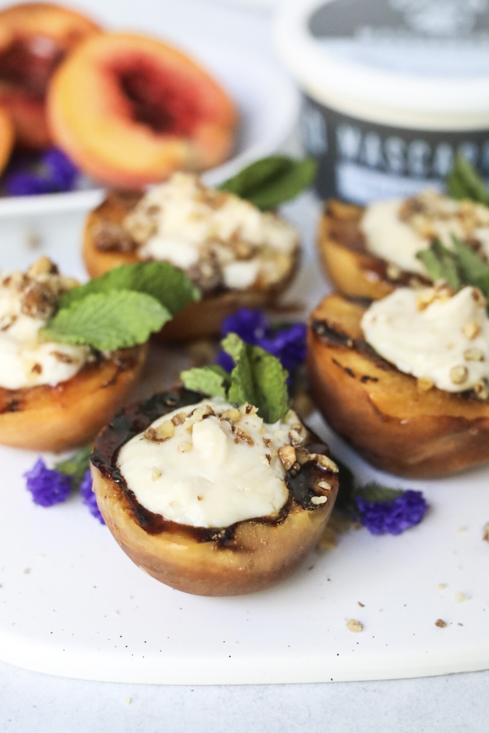 several peaches stuffed with mascarpone and topped with mint and walnuts for garnish