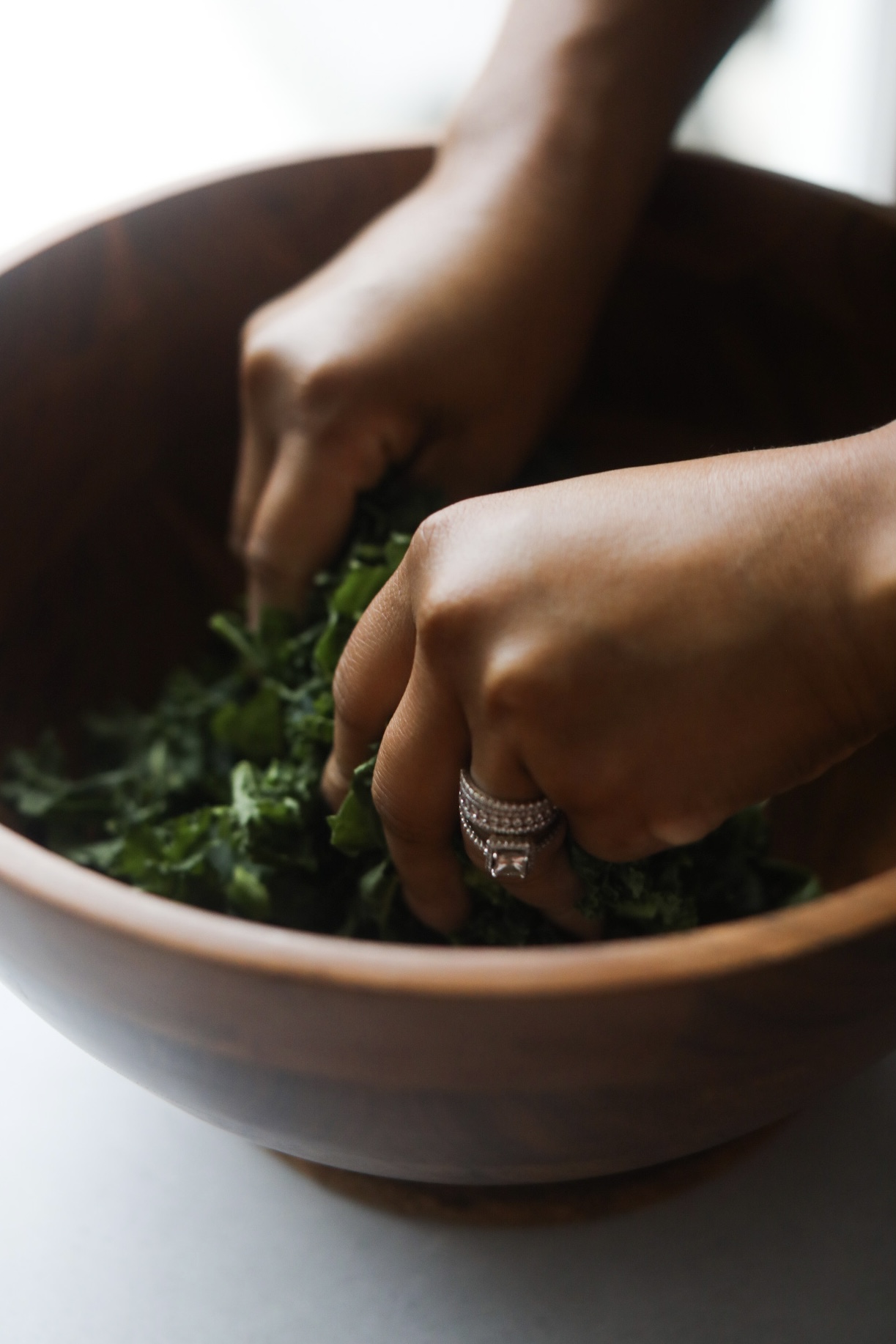 hands massaging kale