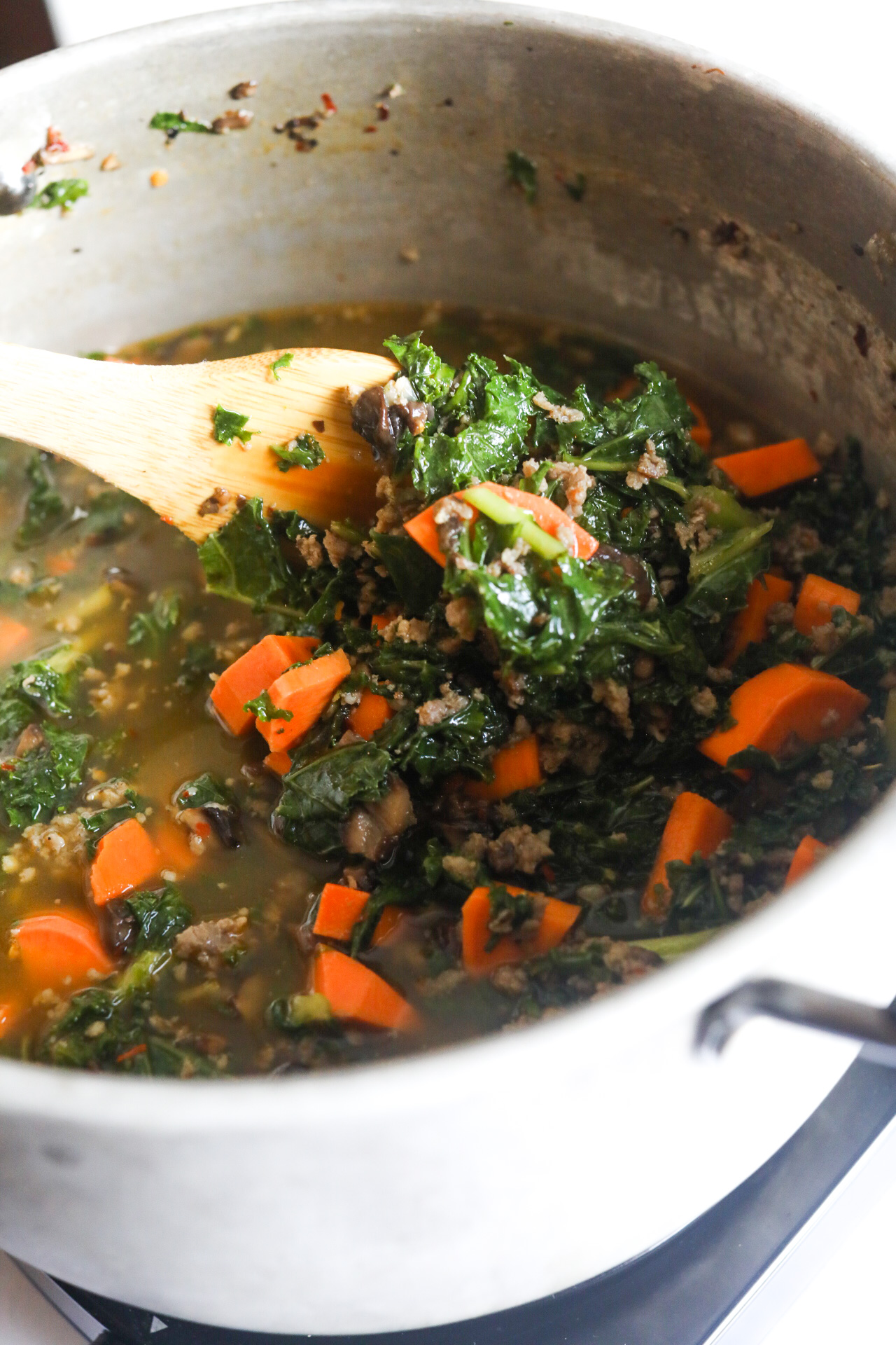 kale being cooked with other ingredients in a pot