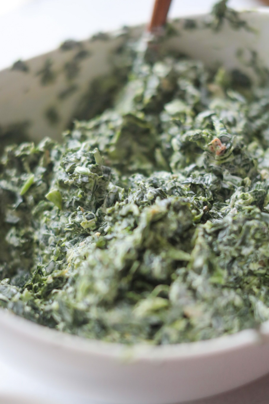 Cold spinach dip ingredients mixed fully in a white bowl.