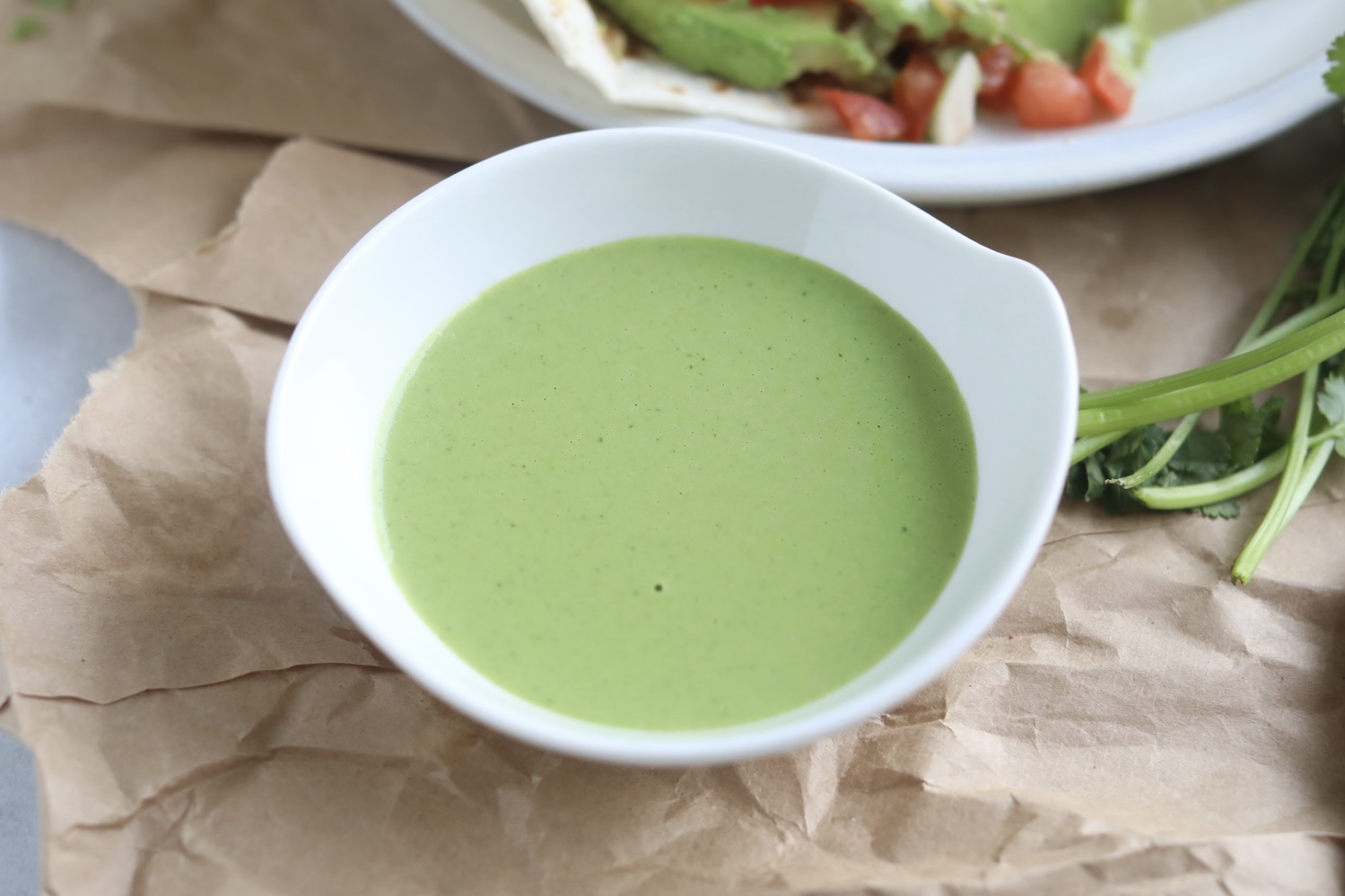 Cilantro lime sauce zoomed in with a small white bowl.