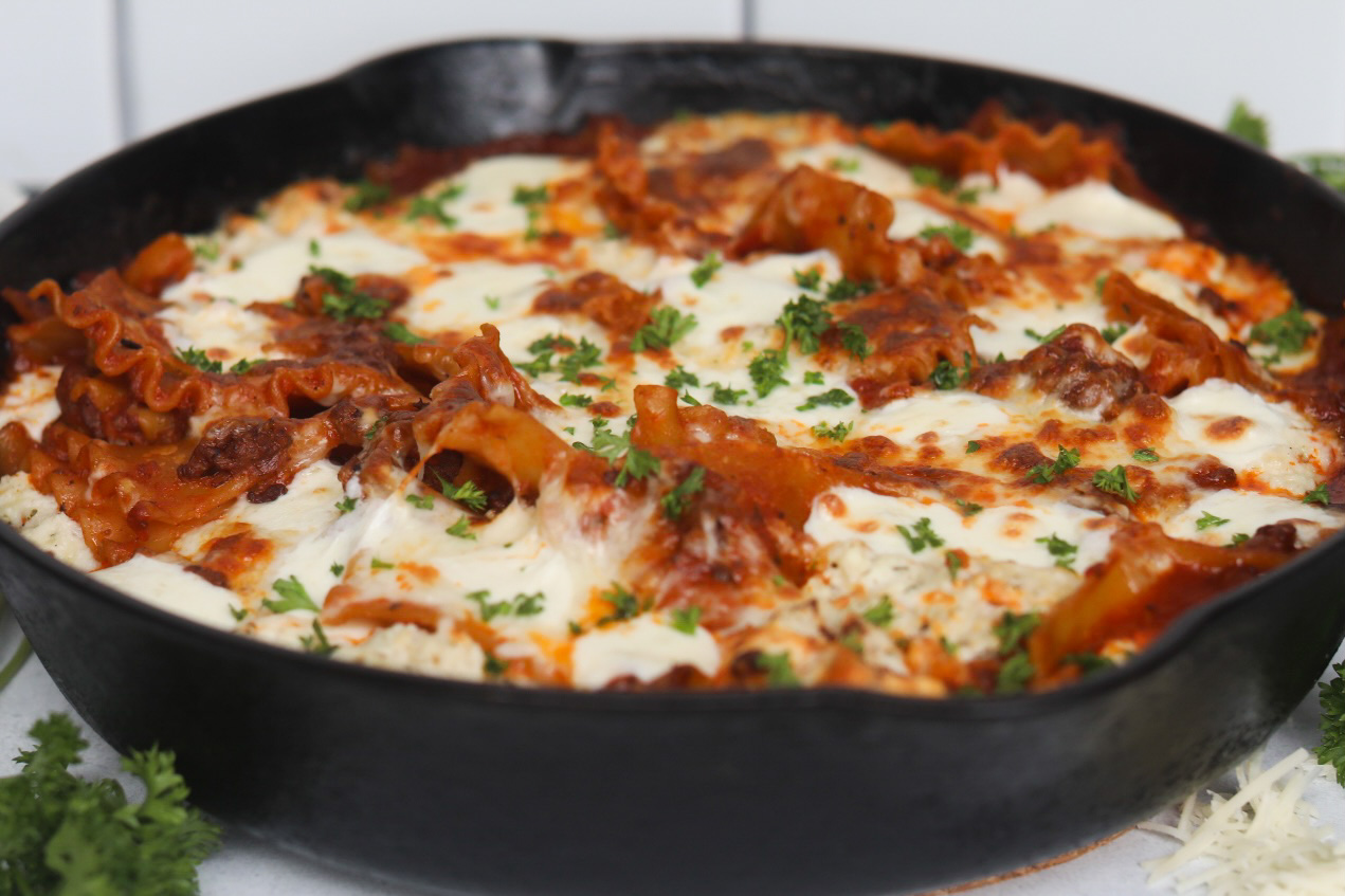 Featured image of plated one pot skillet lasagna in a black cast iron skillet.