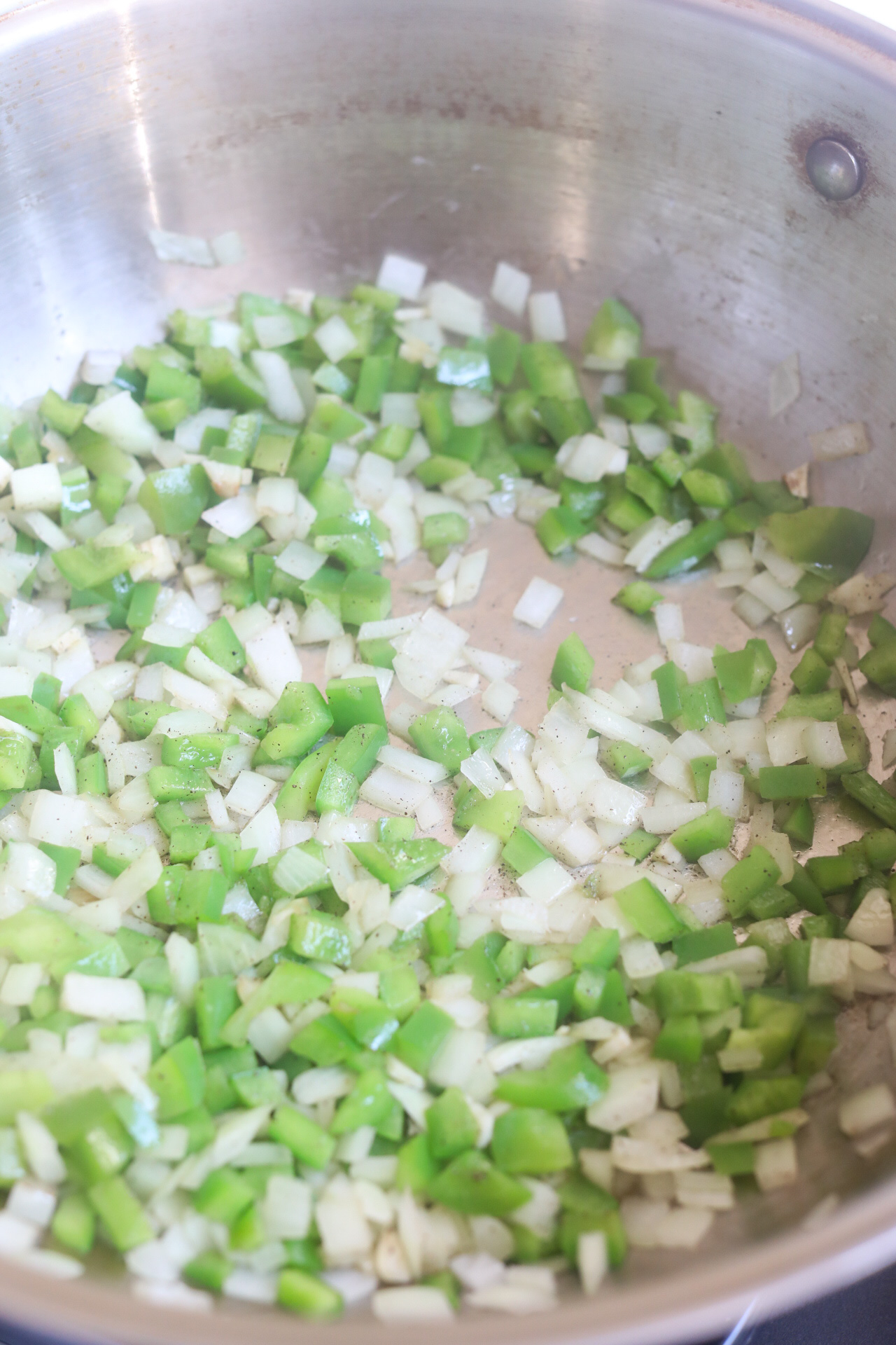 Chopped green peppers and onions in a pan with oil, salt and pepper.