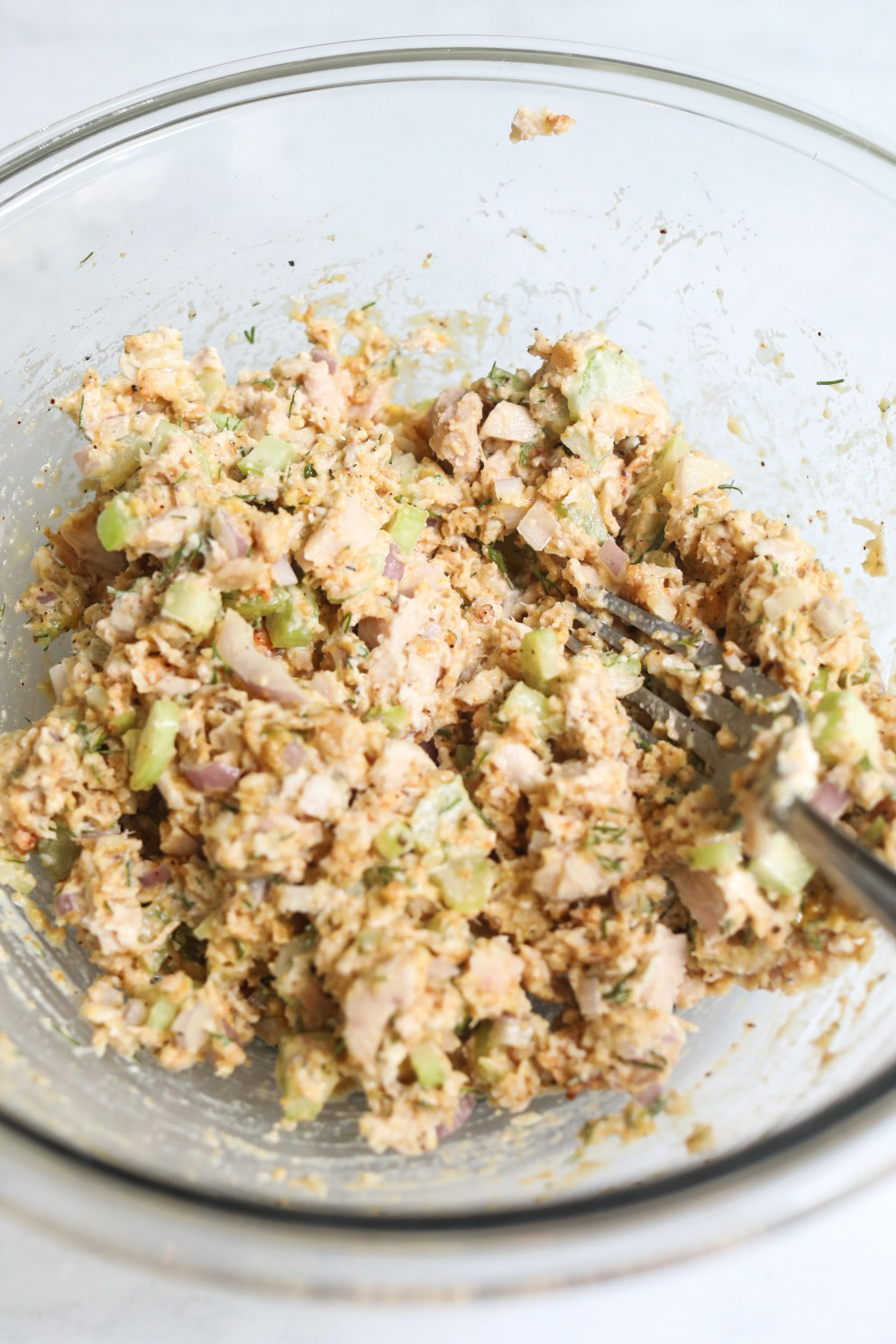 Tuna burger ingredients mixed in a glass bowl. 