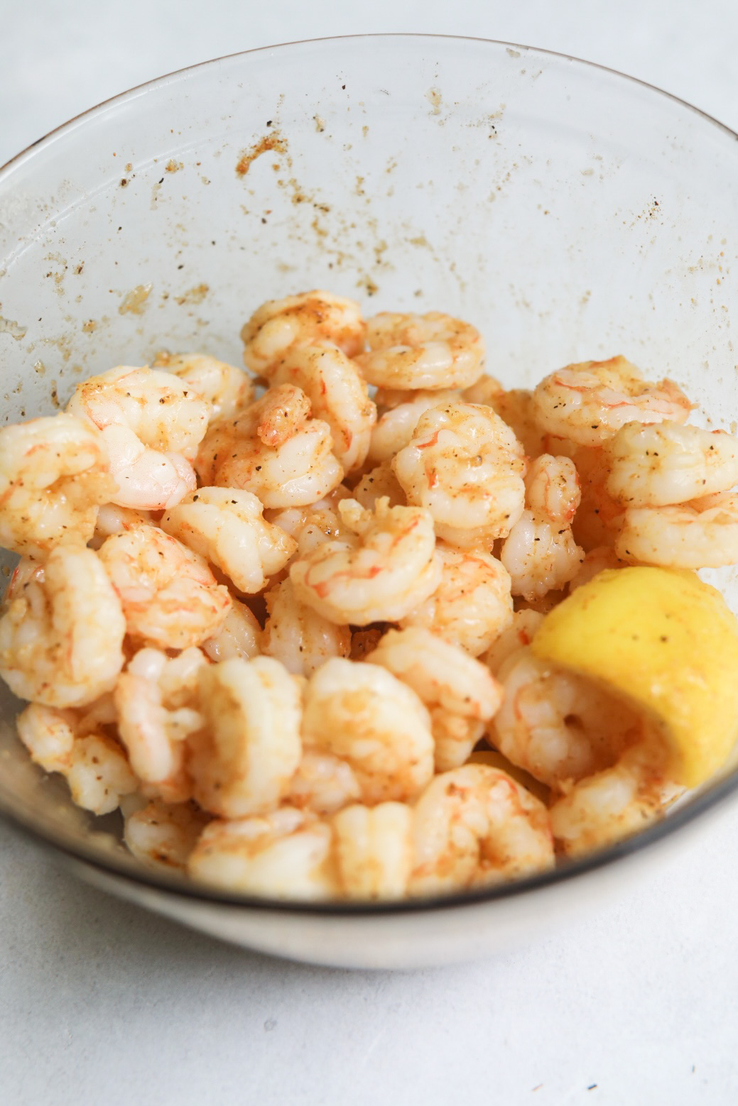 Poached shrimp in bowl, cooked with sliced lemons after boiling.