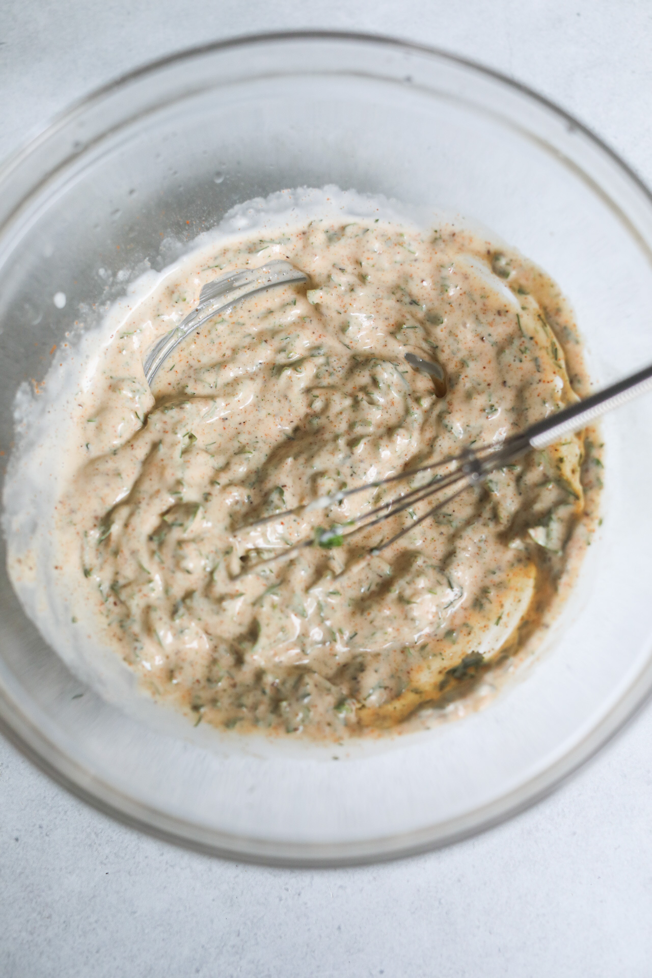 Cajun mayo dressing stirred in clear bowl for shrimp salad.