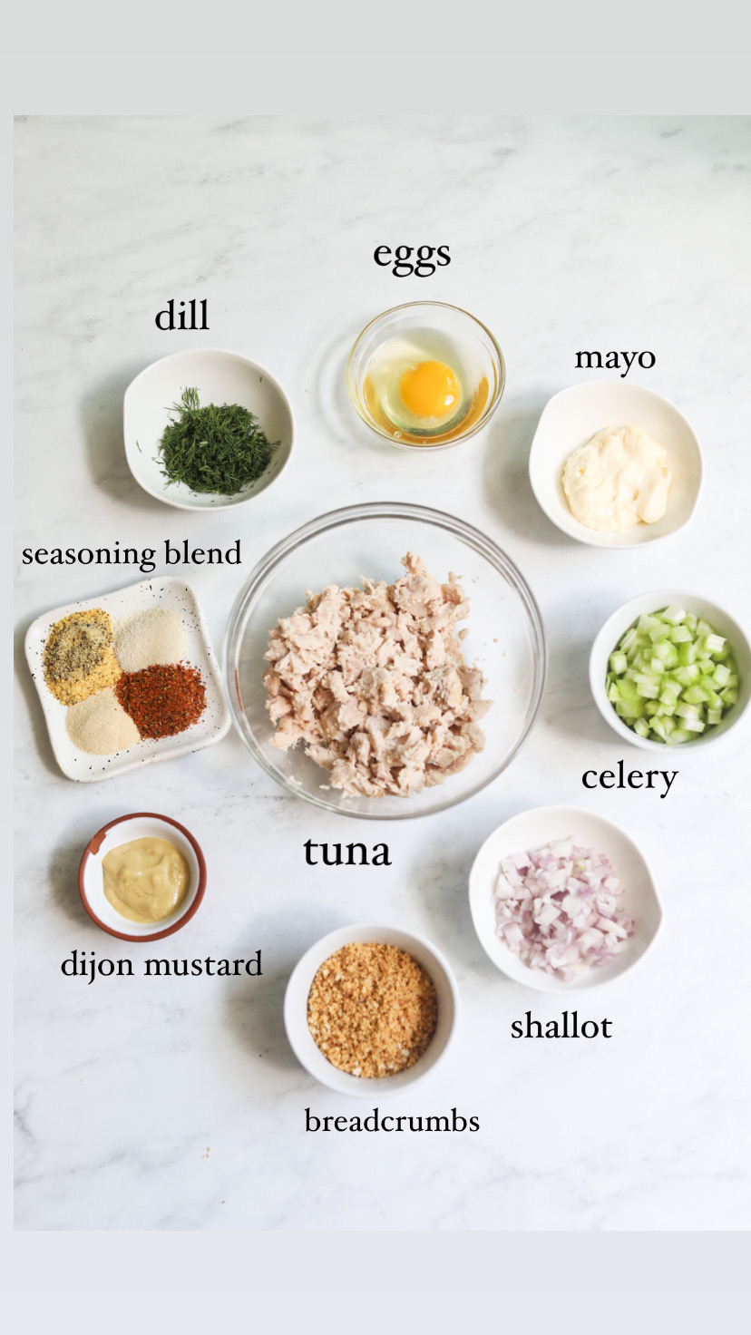 Tuna burger ingredients for patty. In a flat lay, small bowls of mayo, egg, dill, seasoning blend, dijon mustard, breadcrumbs, shallot, celery, tuna and mayo. 