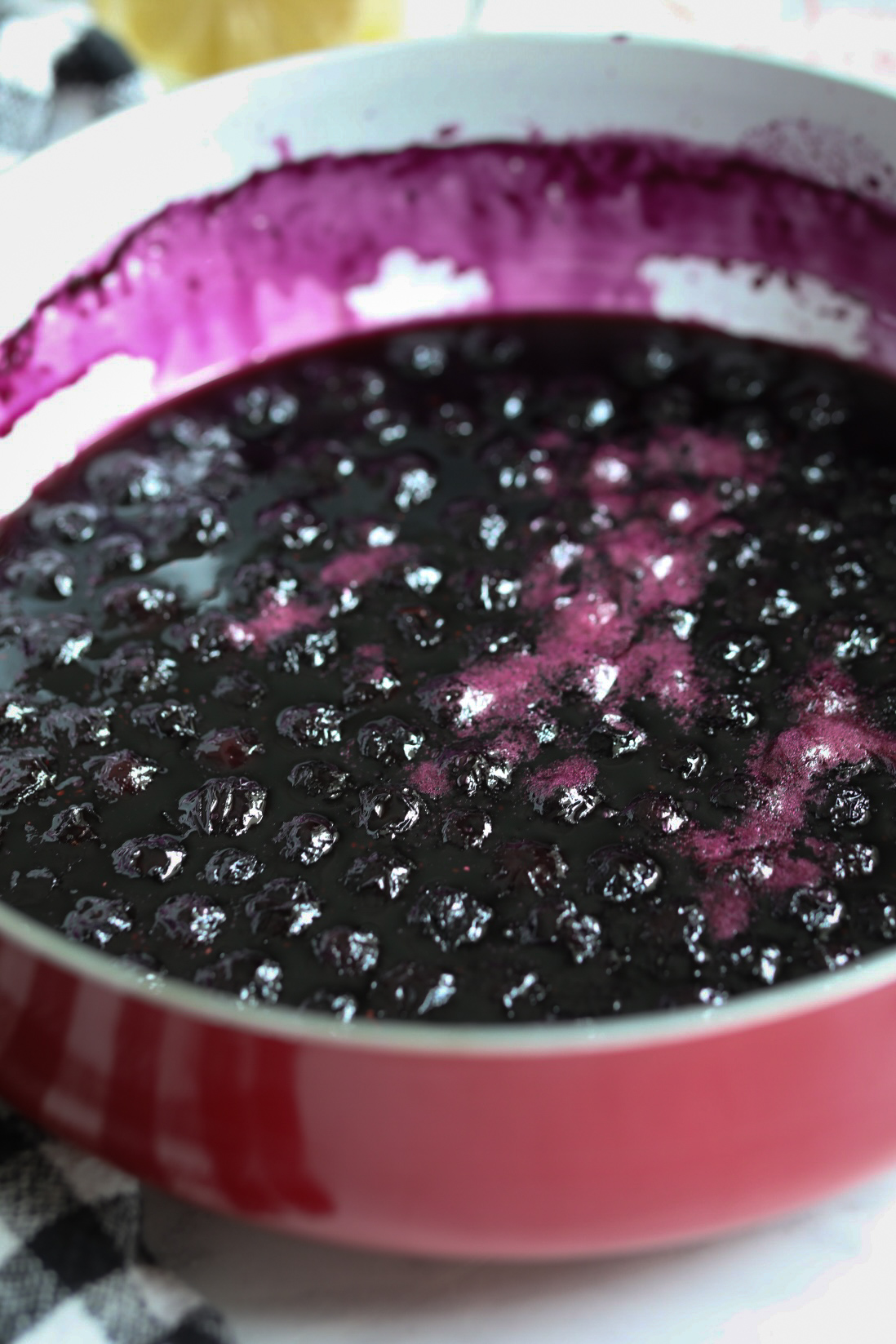 Simple syrup cooked and thickened in a red pot to show contents of recipe at final stages.