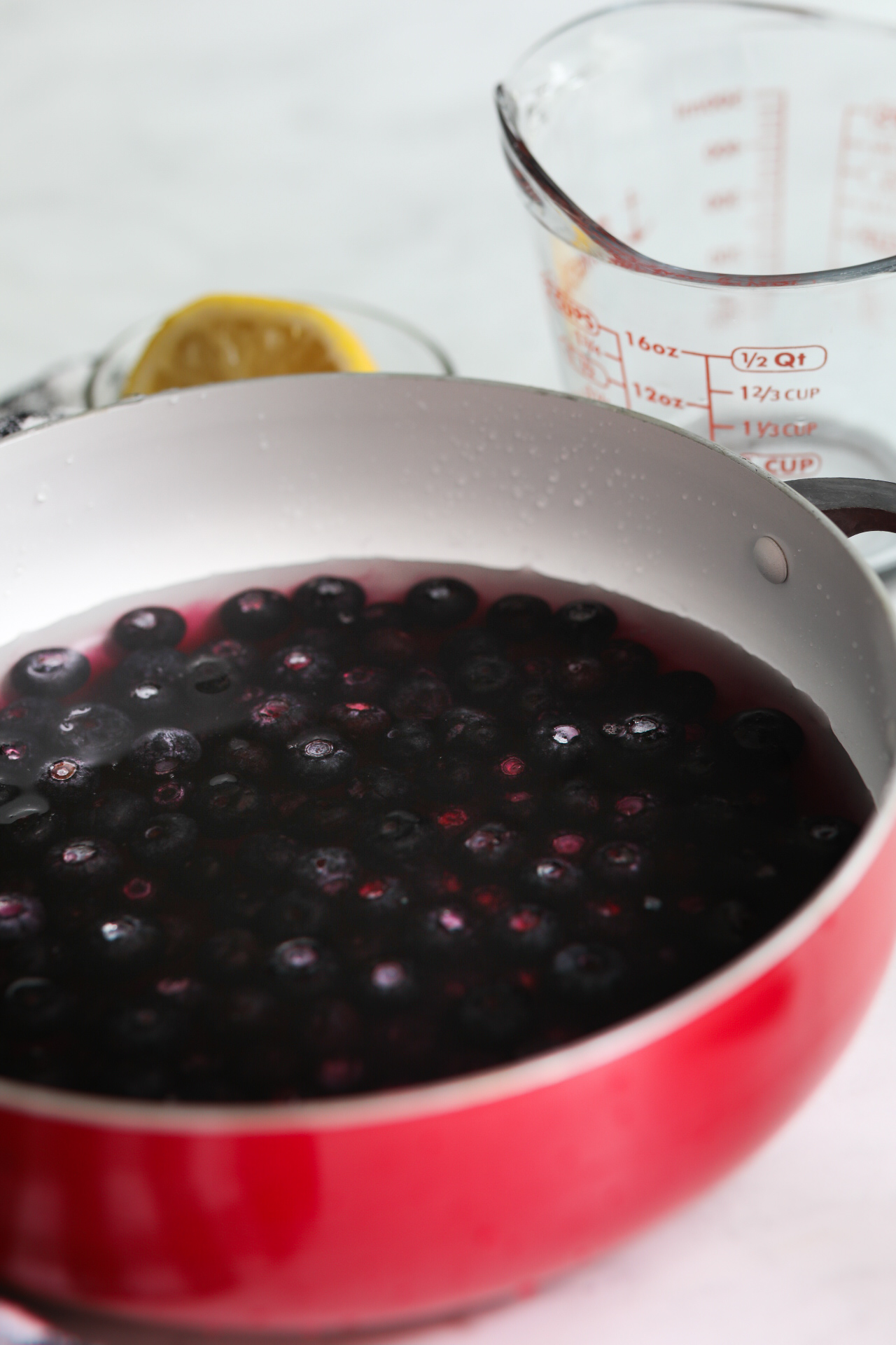 Blueberry syrup ingredients in a large red pot.