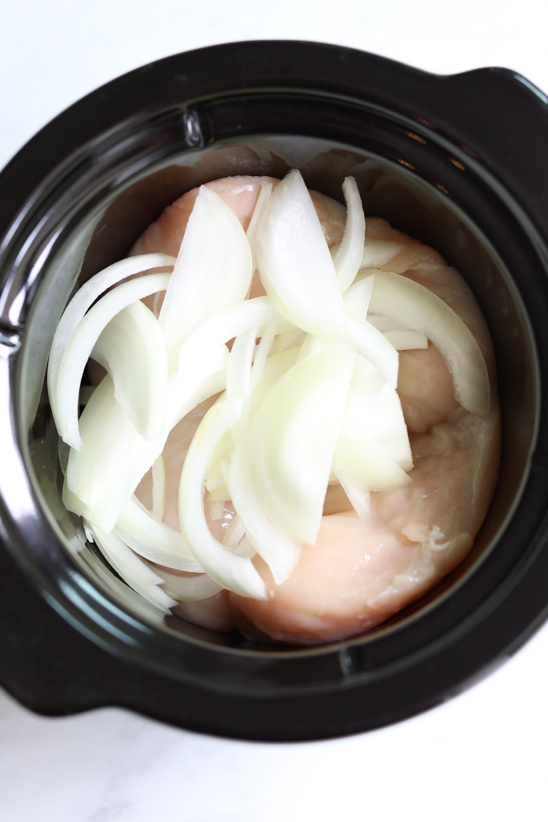 onions and chicken breasts in crockpot