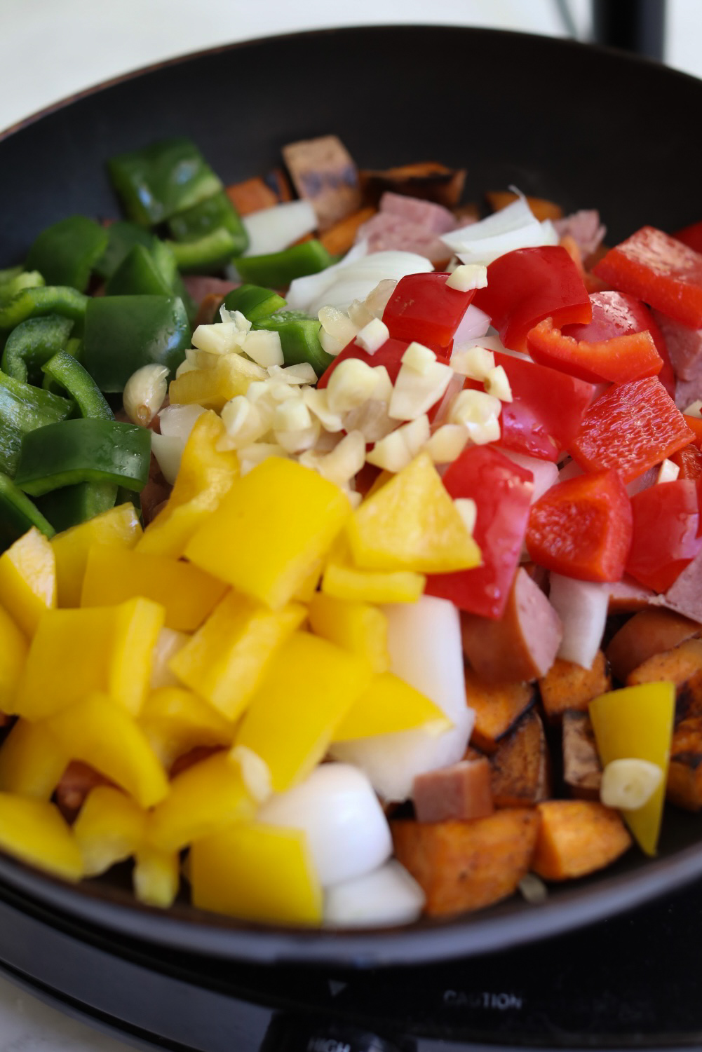 Potatoes with bell peppers, onion and garlic in a small cast iron skillet.