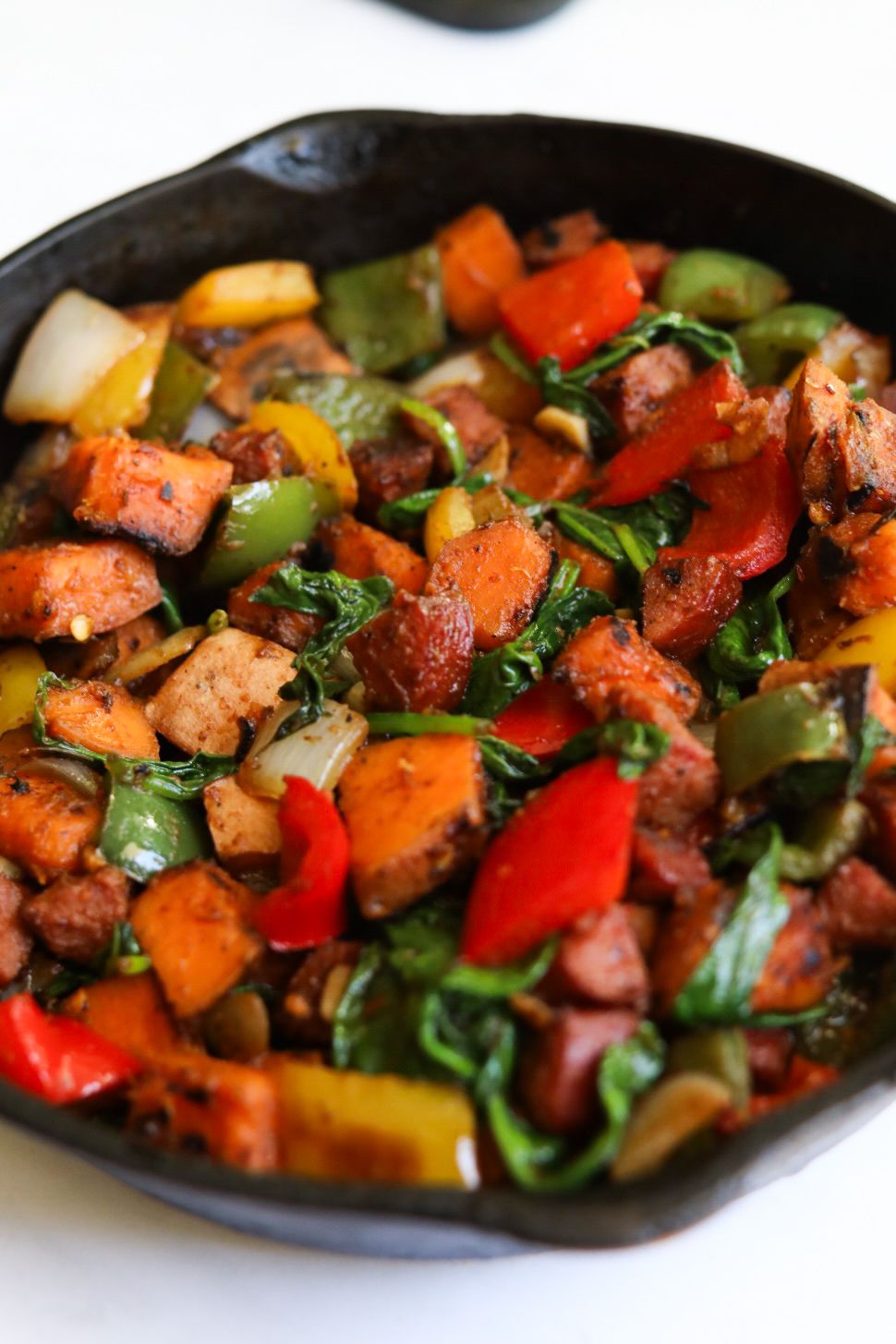 Hash sautéed in black cast iron before being baked in the oven with eggs on top.