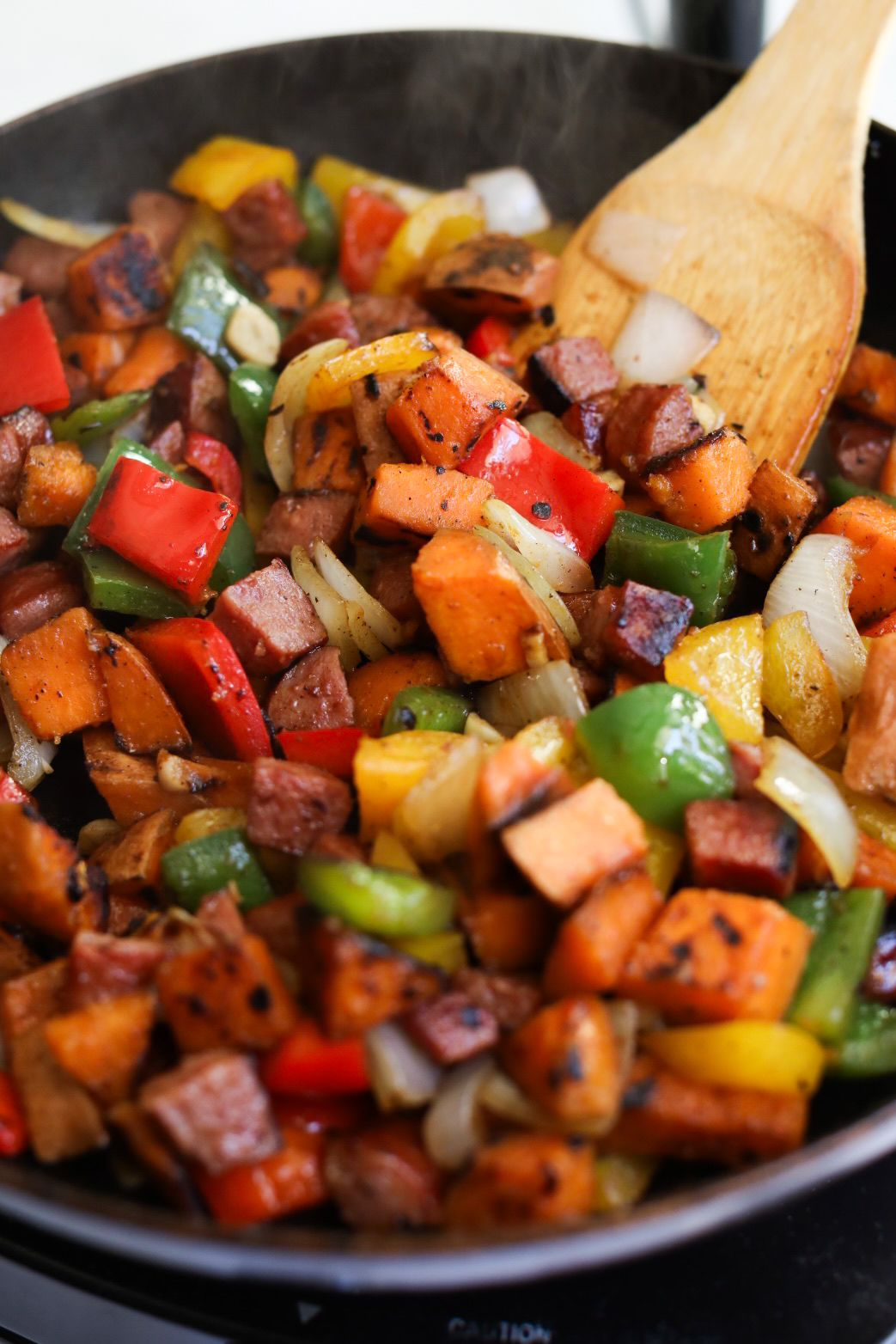 Sweet potato hash, sautéing with all ingredients except spinach in a frying pan.