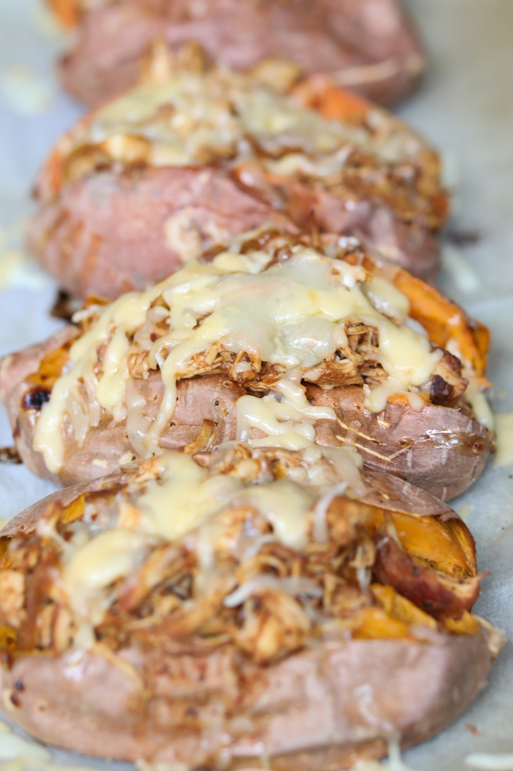 melted cheese over stuffed sweet potatoes