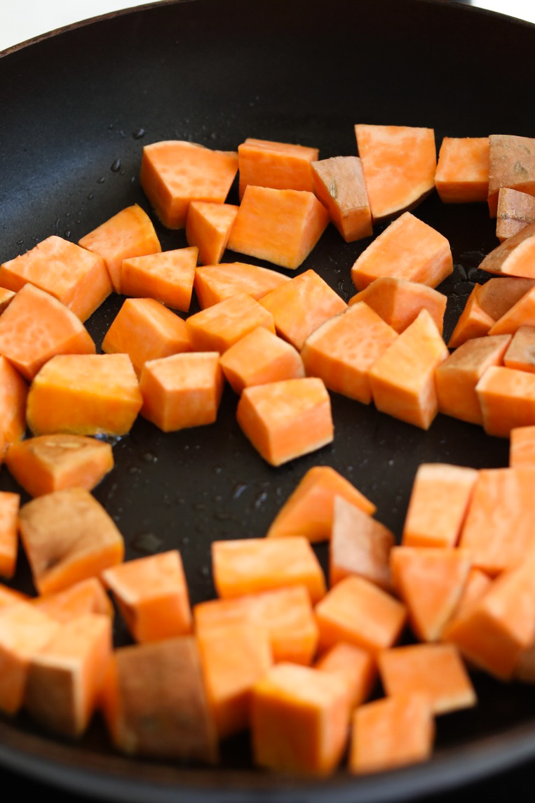 Sweet potatoes diced, sautéing in a pan with light oil.