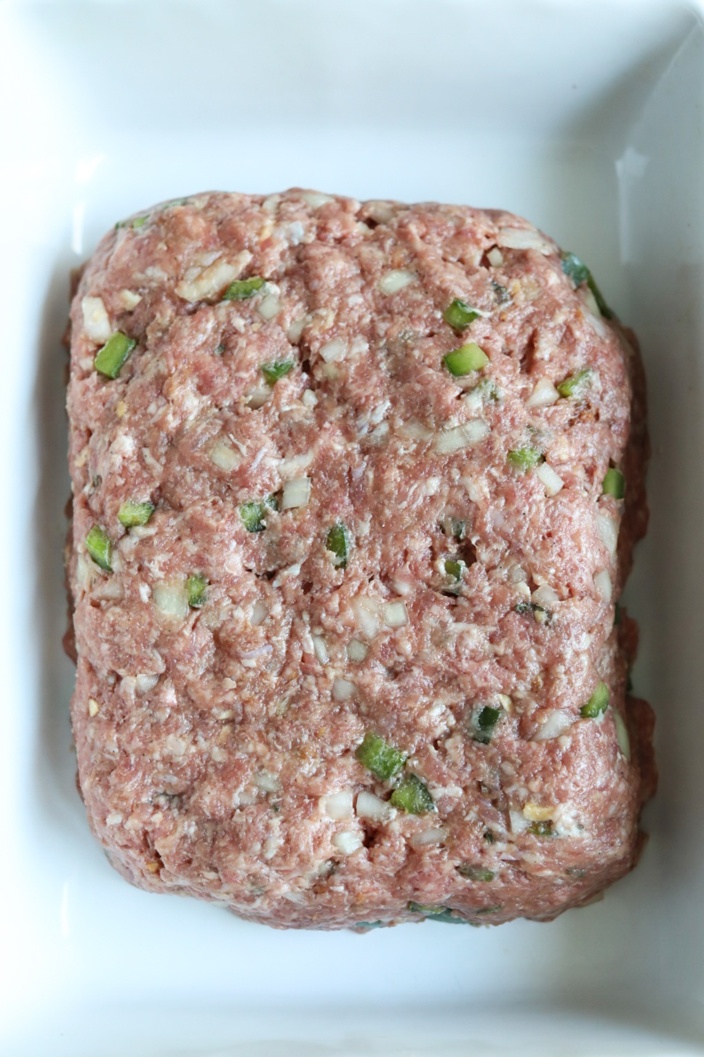 Raw meatloaf in baking pan ready for baking.