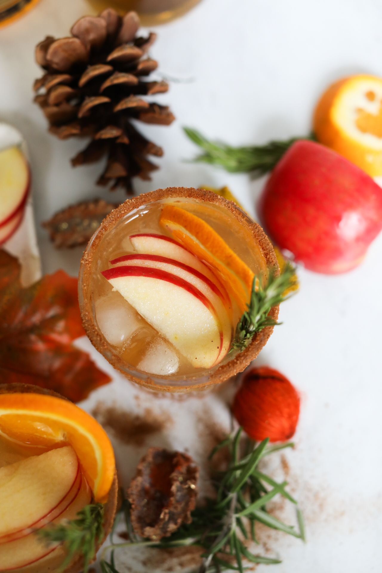 Top down view of Thanksgiving Margarita topped with sliced apple, orange and rosemary sprig.
