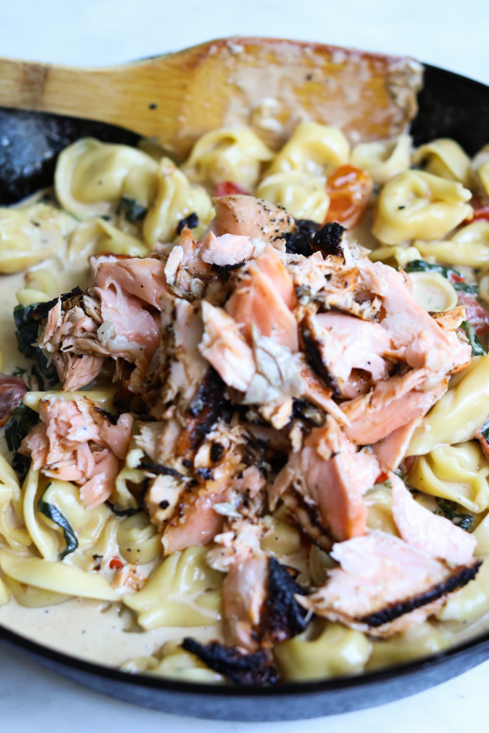 tortellini pasta and salmon added to cream sauce