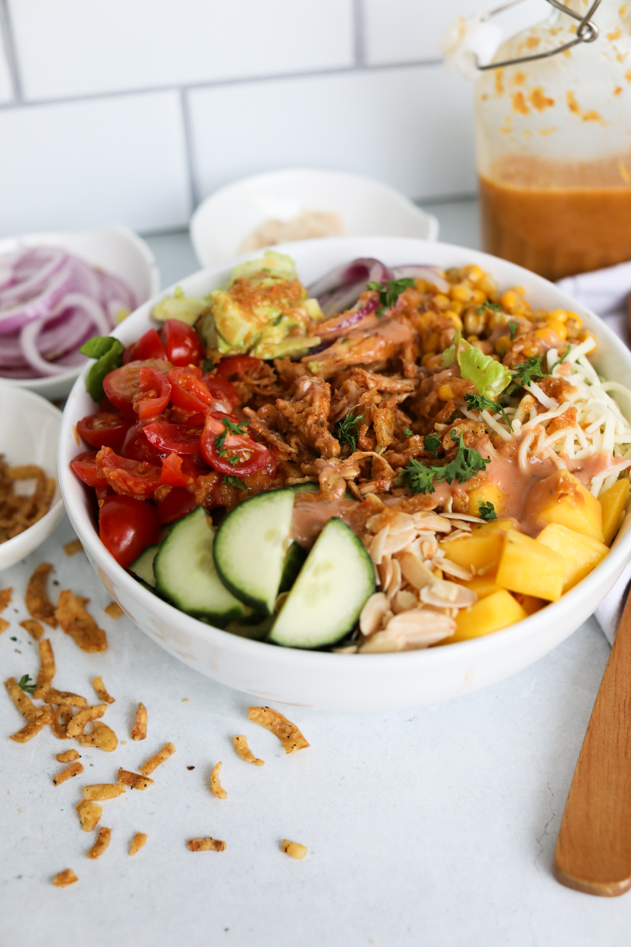 Final recipe image of BBQ Chicken Salad in a white bowl with honey ginger dressing.