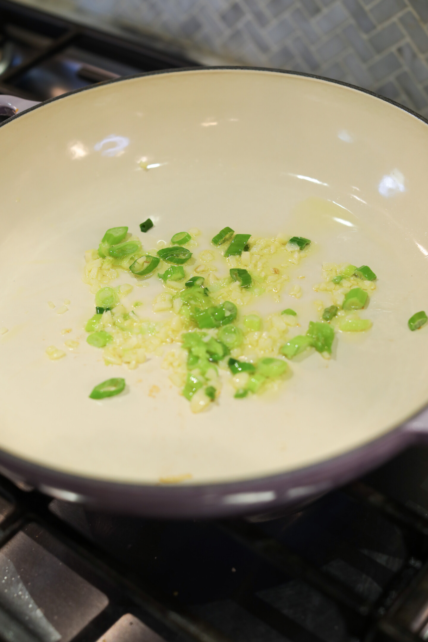 green onions and garlic sauteeing in a pan