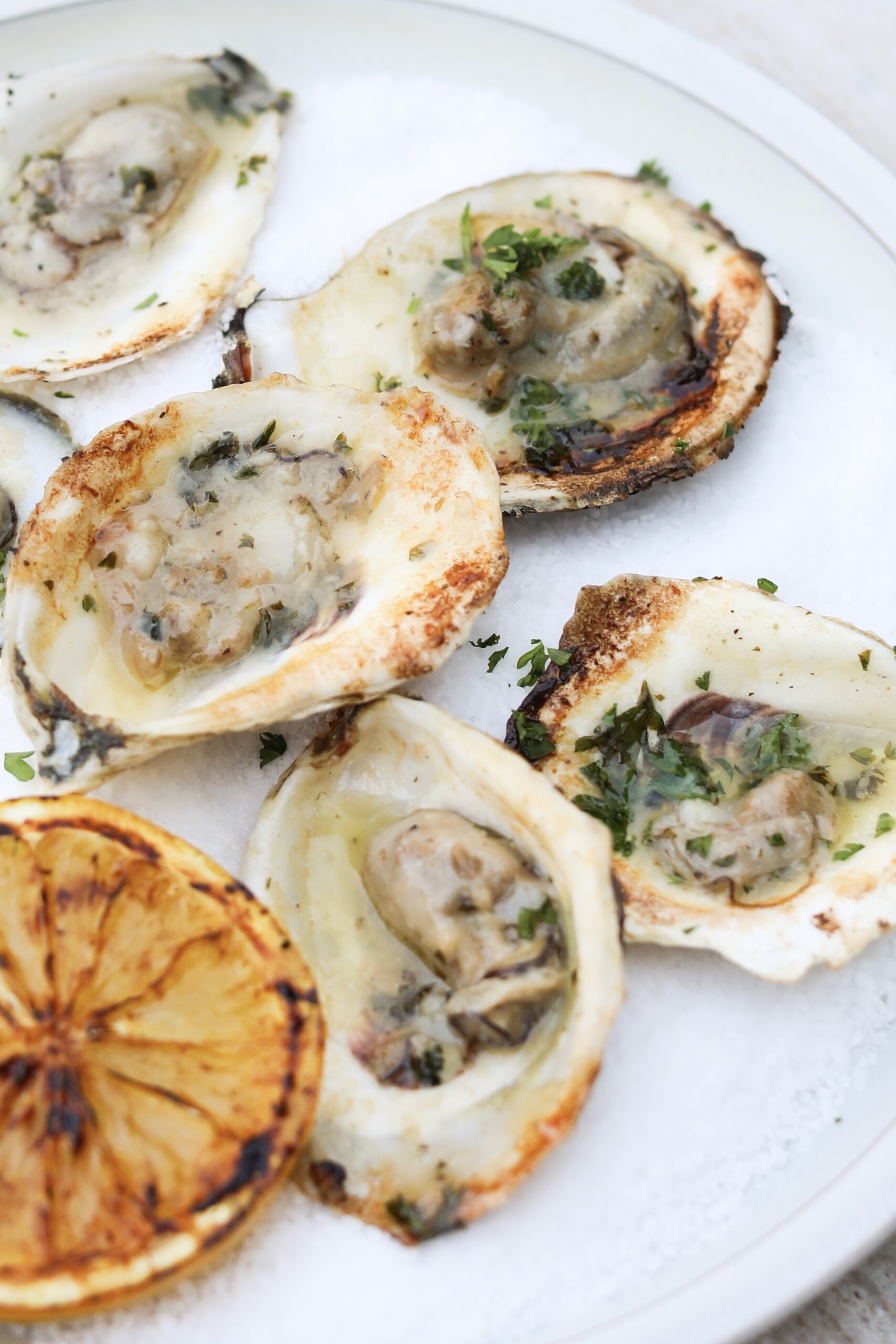 close up view of grilled oysters with lemon wedges