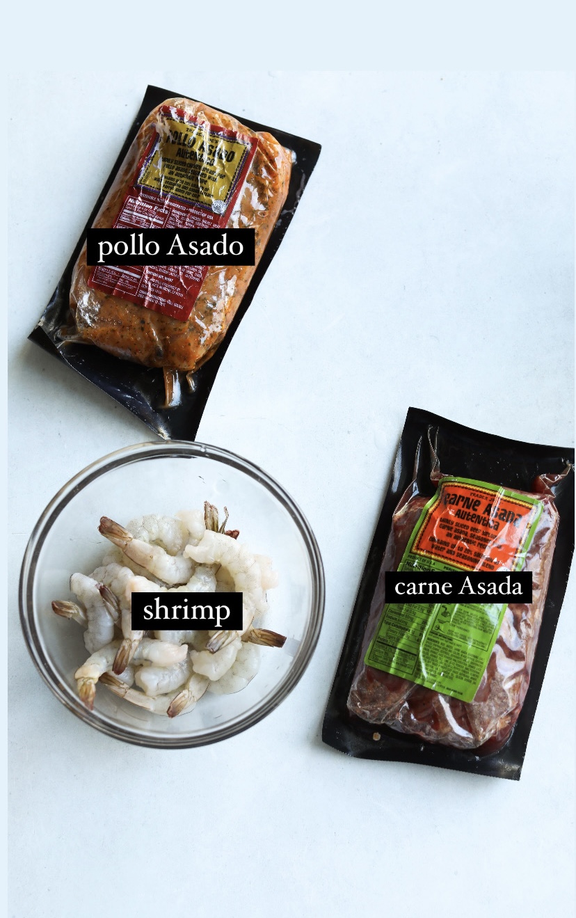 Flat lay of ingredients with pollo asado in packaging, carne asada in packaging, and shrimp.