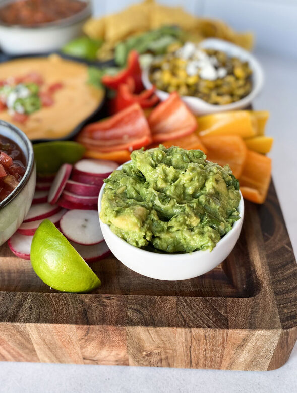 close up view of salsa and guacamole on a charcuterie board