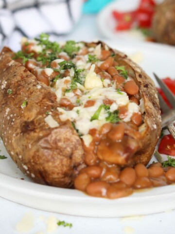 Jacket potatoes with beans, topped with shredded cheese, chives and fresh parsley.