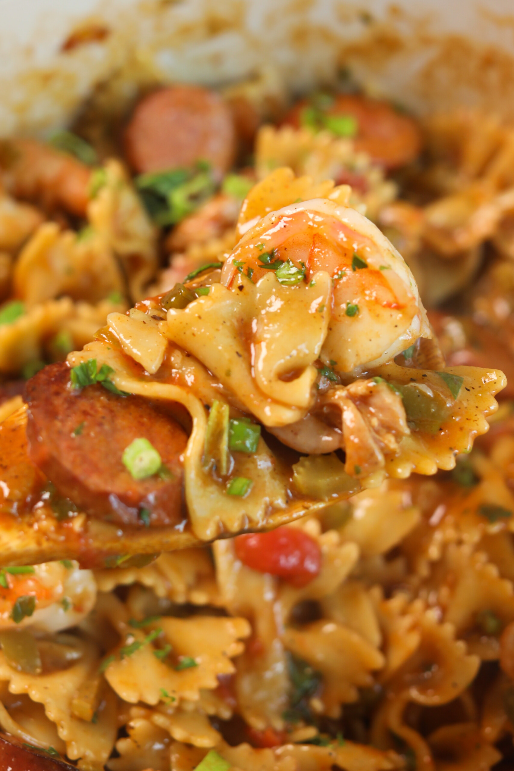 Close up of complete Pastalaya recipe. Wooden spoon, scooping out contents to show recipe.