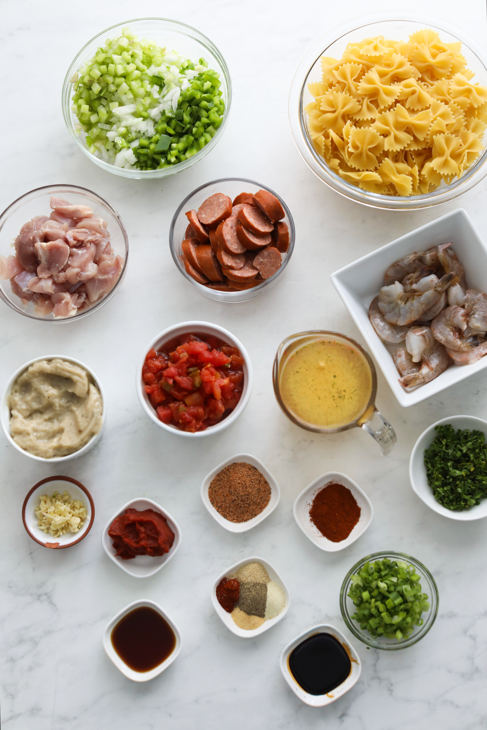 Ingredients for cajun pastalaya. Ingredients are in small bowls coupled together.