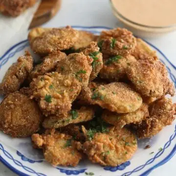 Plated fried pickles on a blue and white plate.